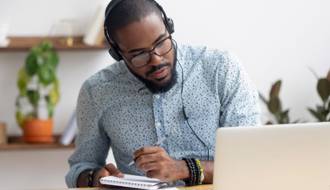 Man taking notes watching a webinar